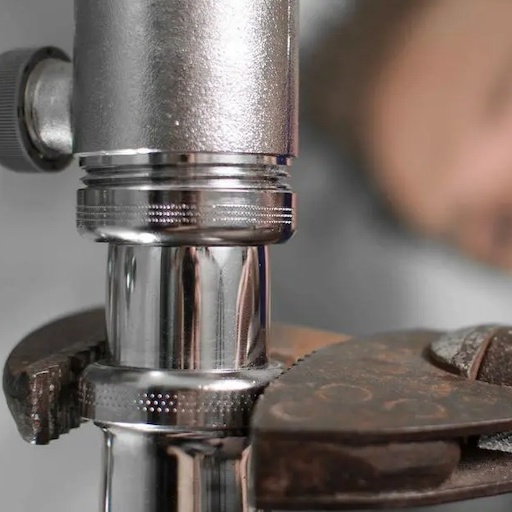 Plumber using a wrench to tighten a pipe.